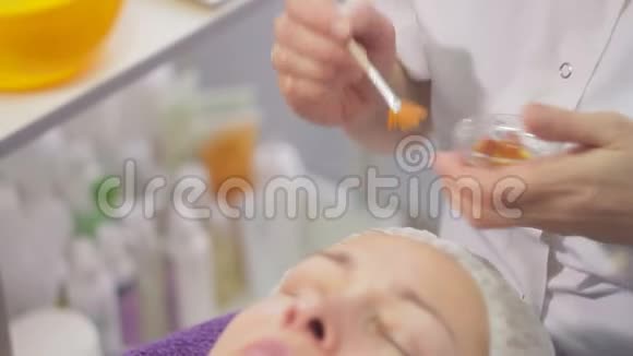 中年妇女美容诊所的手术这位化妆师用一油涂在女人的脸上视频的预览图