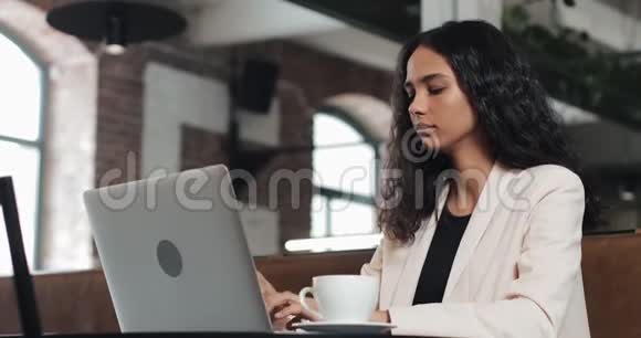 年轻的商务女性完成她的笔记本电脑工作并在现代办公室放松视频的预览图