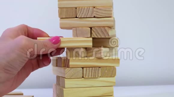 女人试图从坠落的木塔游戏中取出木块视频的预览图