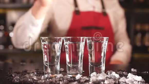 专业男性酒保在酒精饮料中加入冰块视频的预览图