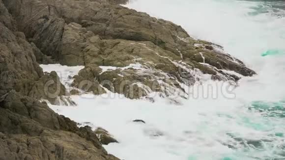 海浪拍打着海洋中的岩石海沫飞溅视频的预览图