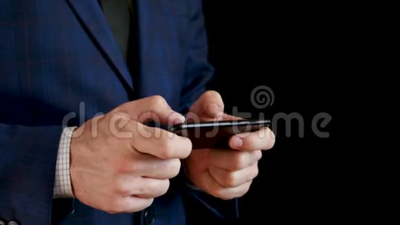 男性手拿着黑色智能手机特写手指在打字时触摸手机的触摸屏商人视频的预览图