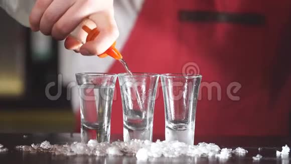 穿着优雅制服的专家酒吧服务员用磨砂短杯倒伏特加视频的预览图