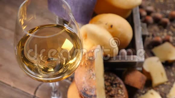 杯中红酒的特写镜头和一套新鲜美味的奶酪放在木箱里葡萄酒和奶酪的概念视频的预览图