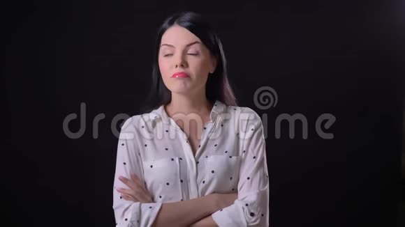 一位体贴的年轻女子在思考和点头在黑色背景下被孤立穿着衬衫的漂亮黑发女士视频的预览图