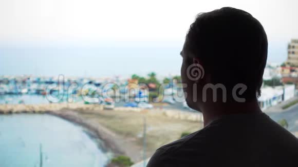 从露台欣赏海景的人剪影从阳台看码头的男性旅行者视频的预览图