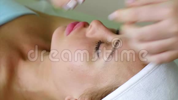 按摩治疗师美容师为美容诊所的女性做颊部按摩视频的预览图