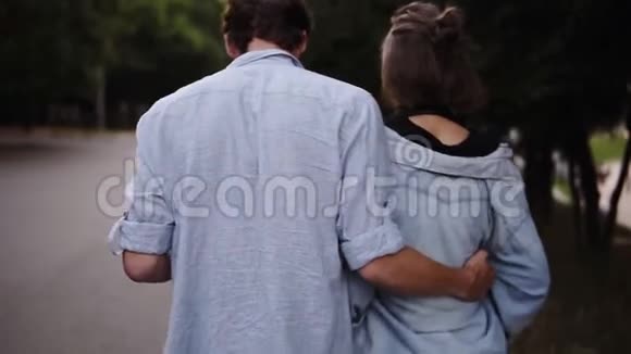 一对年轻夫妇穿着类似的蓝色衬衫在公园散步浪漫平静约会视频的预览图
