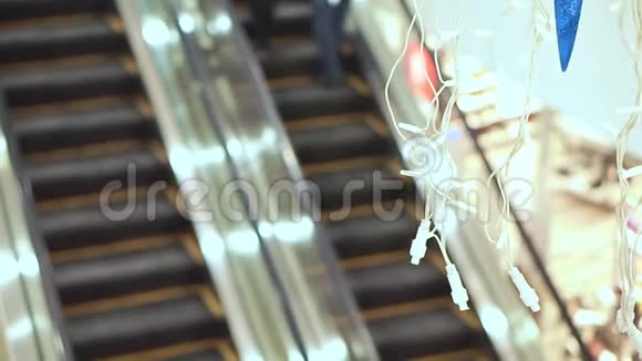 看看商场里空着的自动扶梯穿过圣诞花环出售的买家去自动扶梯视频的预览图