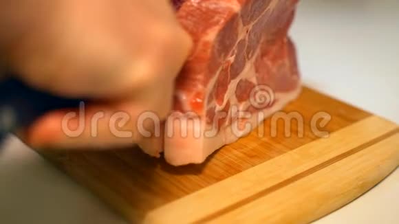男性手在木板上切肉做牛排视频的预览图