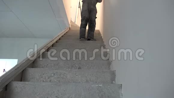 工人在楼梯上用滚筒画天花板视频的预览图