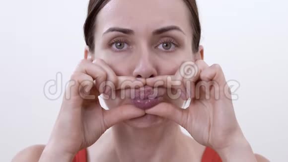 一个黑发女人做运动以保持嘴唇的形状和健康避免他们变老的肖像视频的预览图