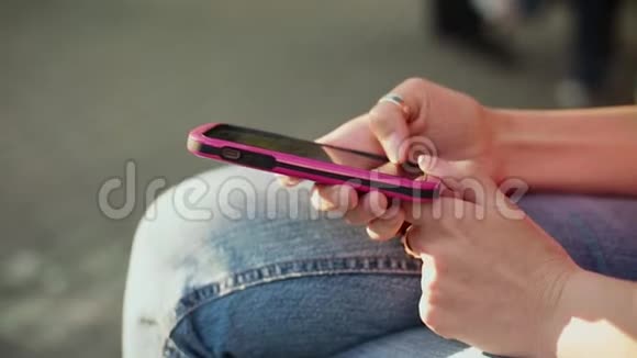 年轻女性的特写双手在智能手机上滚动图片视频的预览图