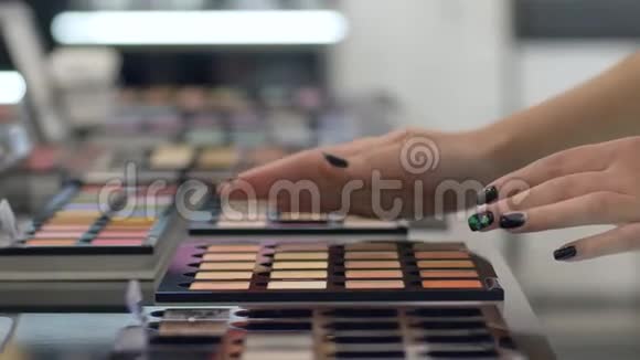 专业化妆客户女孩的手臂选择不同颜色的调色板的眼影专业化妆视频的预览图