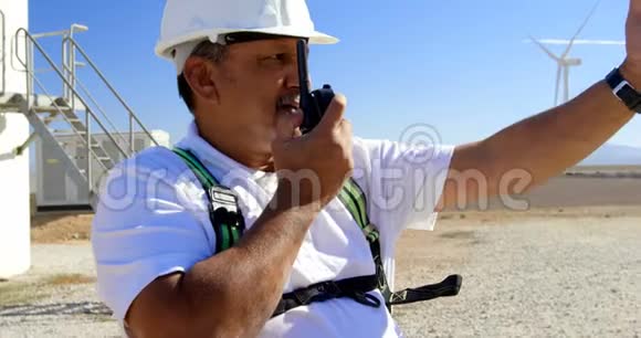 男工程师在风电场里用对讲机说话视频的预览图