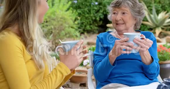 在家院子里喝咖啡的老妇人和少女视频的预览图
