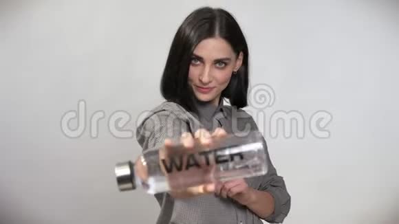 年轻漂亮的女人棕色短发拿着瓶子相机里拿着水露出大拇指快乐视频的预览图