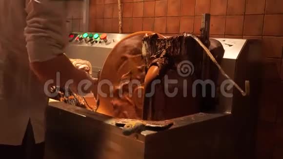 搅拌机热巧克力熔化的致密物质在一个大缸中旋转牛奶巧克力从金属里倒出来视频的预览图
