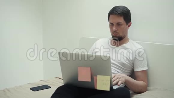 一个人坐在沙发上用笔记本电脑打字旁边是电话视频的预览图