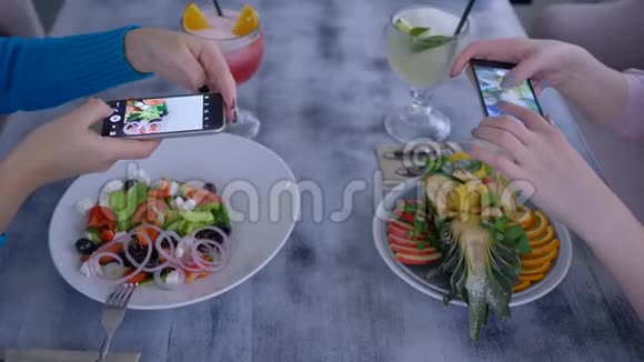 素食女孩在餐厅健康午餐期间用手机为社交网络拍照美味佳肴视频的预览图