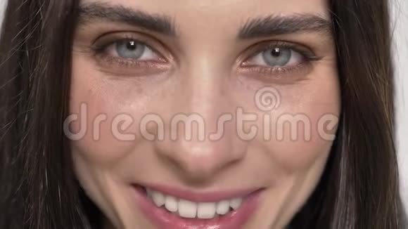 蓝眼睛的年轻迷人女人的肖像直视镜头笑着快乐白色的背景视频的预览图