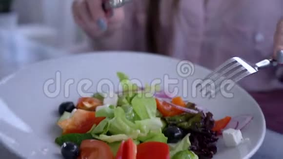 美丽的饮食食物女性用手拿刀叉切新鲜黄瓜在希腊沙拉特写视频的预览图