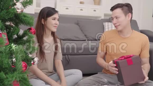 在圣诞节的时候亚洲夫妇在家里的客厅里给他的女朋友送圣诞礼物视频的预览图
