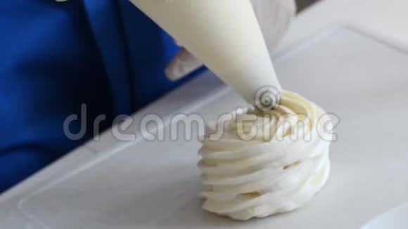 厨师用糖果袋挤压奶油馅到巴夫洛娃蛋糕视频的预览图