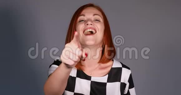 红头发的女人穿着黑白相间的手指对着镜头做手势微笑着视频的预览图