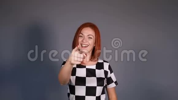 红头发的女人穿着黑白相间的手指对着镜头做手势微笑着视频的预览图
