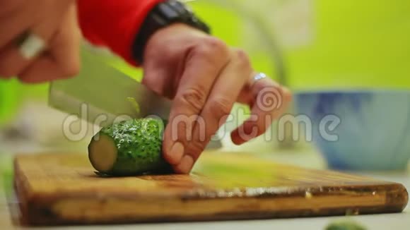 男人用刀子切黄瓜用木头做蔬菜沙拉视频的预览图