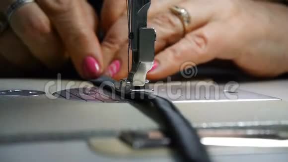 裁缝的特写女裁缝的手在工作用黑色材质的缝纫机缝制时尚视频的预览图