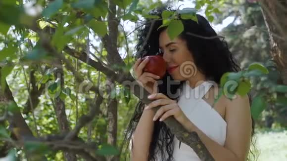 带着红苹果的迷人女人享受水果的味道微笑着拍照视频的预览图