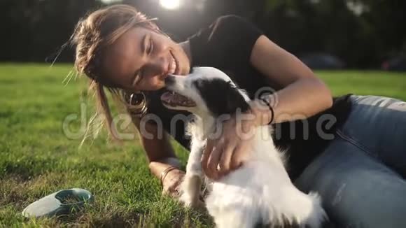 微笑的女士和她的狗在空闲时间女人和她的小狗在大自然中放松把她抓回来狗狗视频的预览图