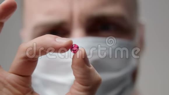 戴口罩的年轻医生检查药丸视频的预览图