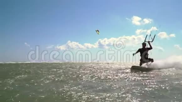 一个戴着帽子的人做一个风筝酒吧在水上表演花样动作缓慢视频的预览图