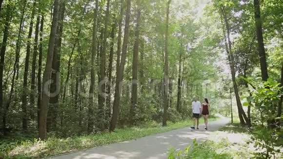 情侣们在阳光明媚的一天牵着手在公园里散步视频的预览图