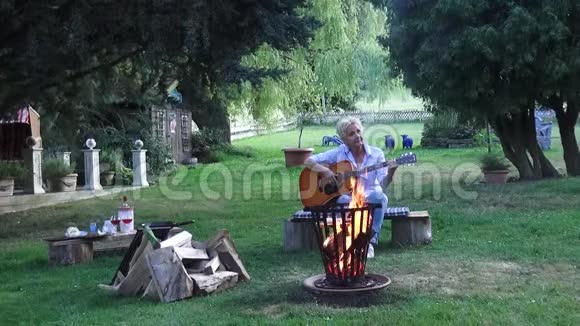 炽热的火焰和烟雾伴随着美丽的女人听吉他上的歌视频的预览图