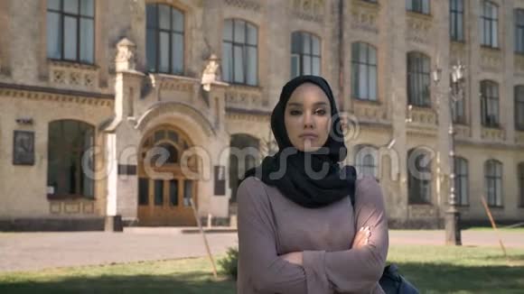 年轻自信的穆斯林女孩正站在夏天的白天双臂交叉在镜头前看着继续前进视频的预览图