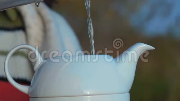 近景慢动作一喷水注入白瓷茶壶视频的预览图