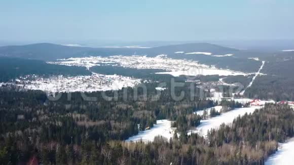 鸟瞰冬季景观与雪松林和滑雪场与藤萝录像无尽的俯视视频的预览图