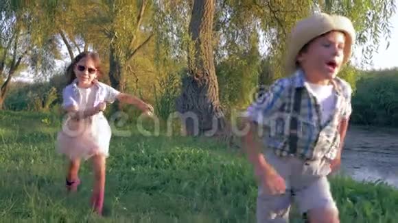 孩子们在户外游戏孩子们在村子里跑步和玩耍在背光下接球视频的预览图