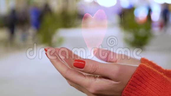 女性手拿着红色心脏的概念全息图视频的预览图