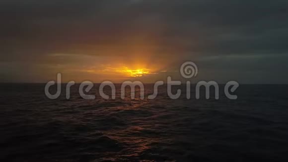 在海浪之上缓慢地飞向美丽多彩的日落在公海上拍摄美丽夜晚的无人机视频的预览图