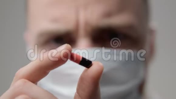 戴口罩的年轻医生检查药丸视频的预览图