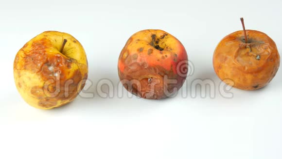 雌性手拿成熟的苹果放成熟的多汁和新鲜的多色白色背景下腐烂变质的苹果视频的预览图