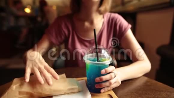 嬉皮士女人在咖啡馆里喝冰蓝色柠檬水和鸡肉视频的预览图