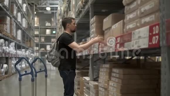成年男子是在仓库里的货物他会装进购物车视频的预览图
