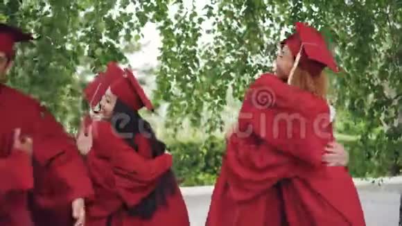 毕业典礼结束后身穿长袍手拿砂浆板的毕业生朋友们互相祝贺视频的预览图