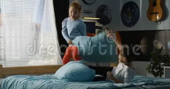 在床上玩枕头大战的男孩和女孩视频的预览图